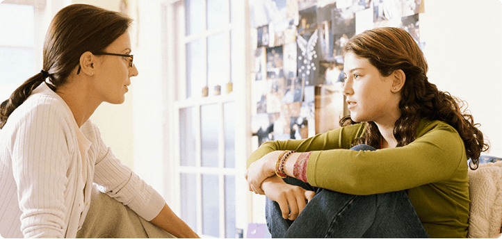 A parent and teen sitting together having a serious conversation