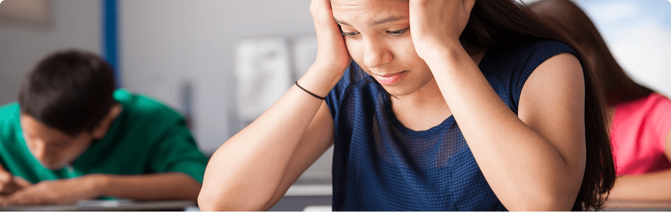 Teen feeling overwhelmed and stressed in a classroom setting